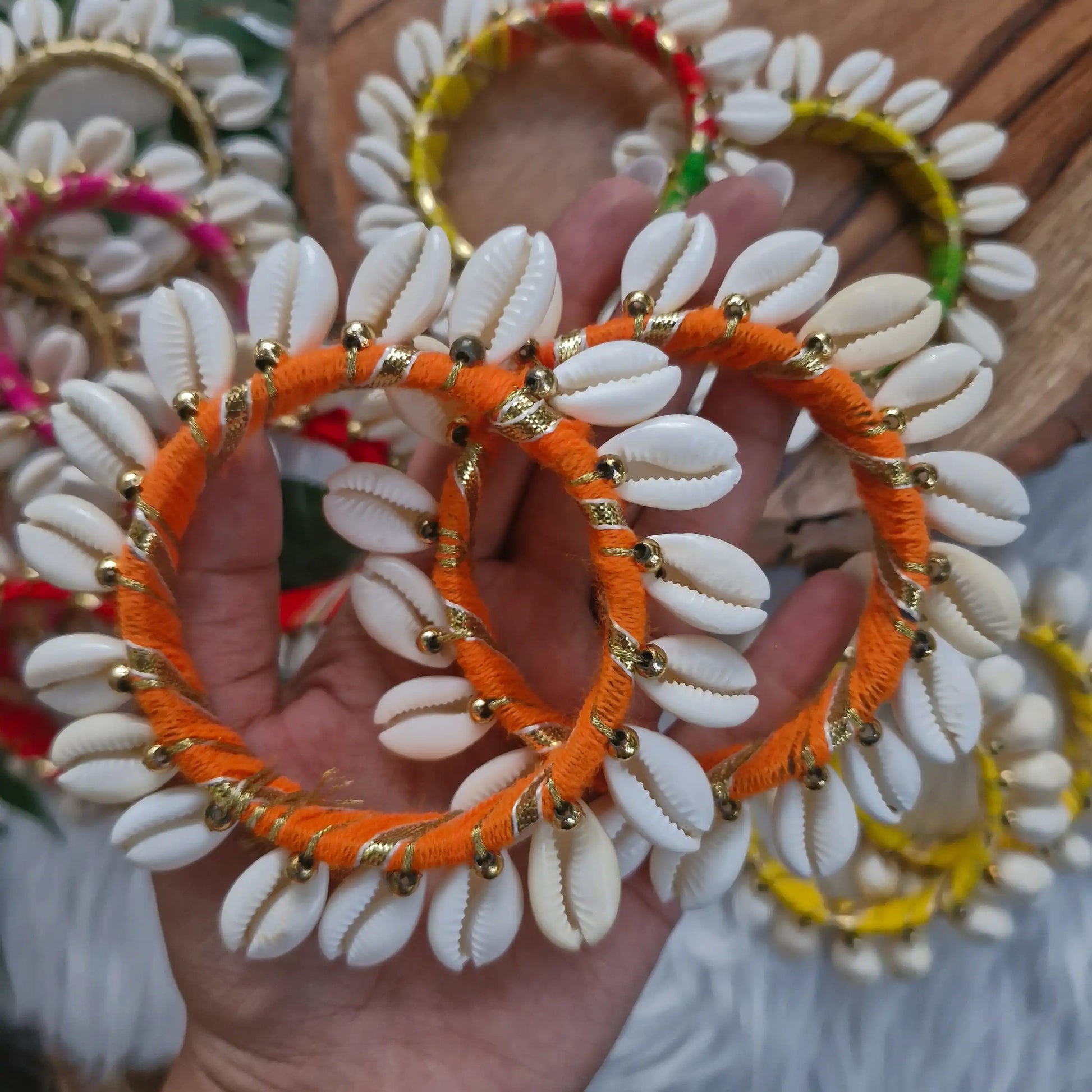Handmade cowrie shell bangle wrapped in orange thread for Diwali and festive décor